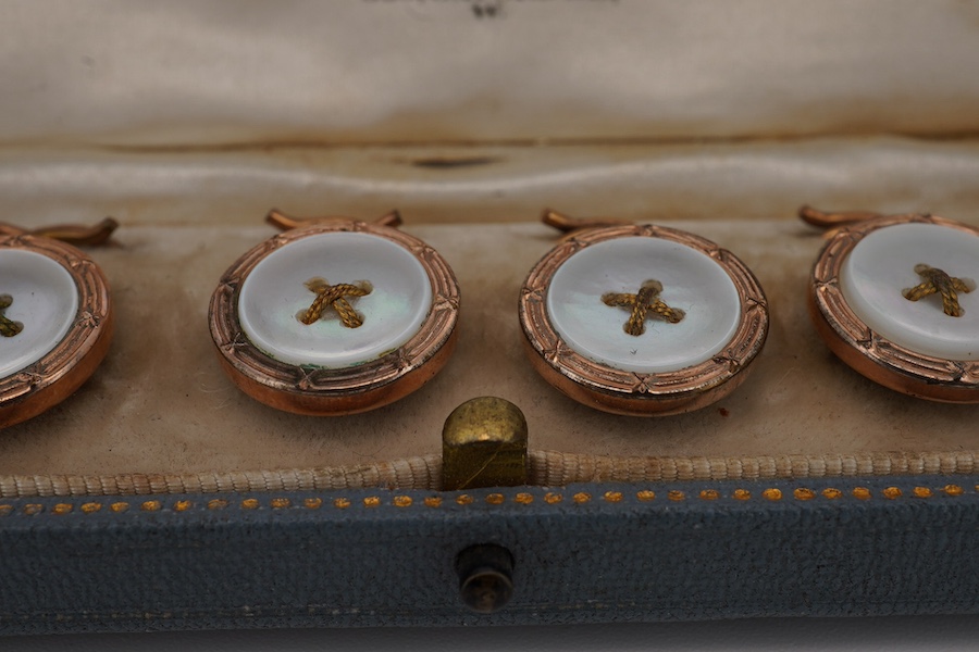 A cased early 20th century gilt metal and mother of pearl set six piece dress stud set. Condition - fair to good